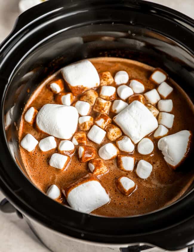 A crock pot filled with chocolate and marshmallows.