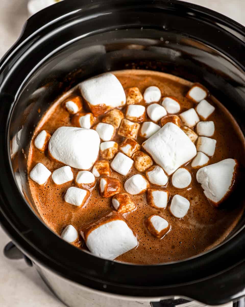 A crockpot filled with hot chocolate and marshmallows.