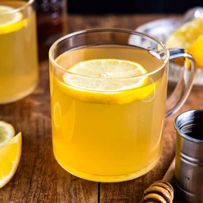 A cup of lemon tea with a slice of lemon.