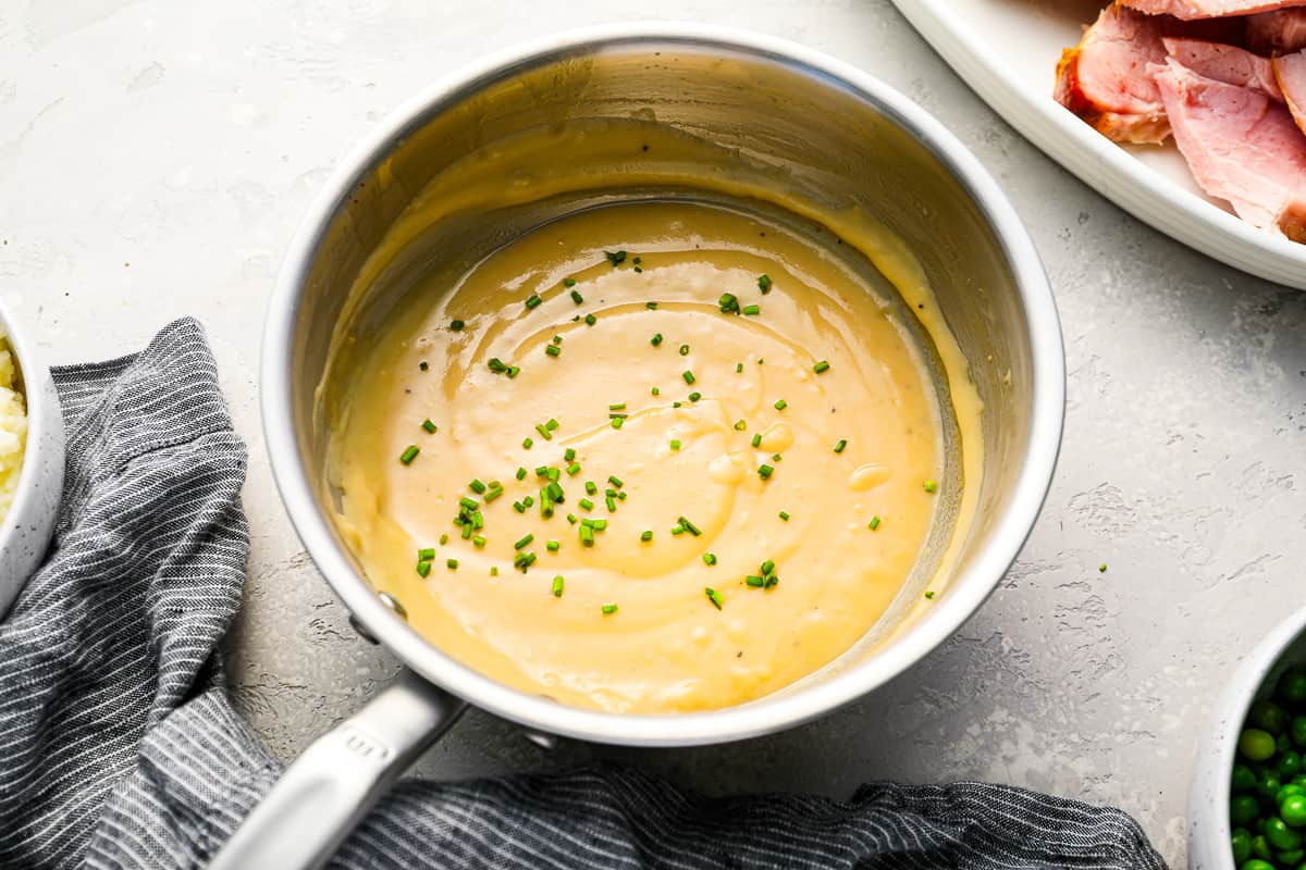 Ham, peas and gravy in a pan on a table.