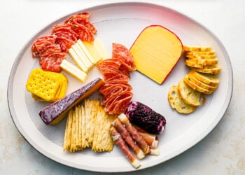 A plate with a variety of cheeses and crackers.