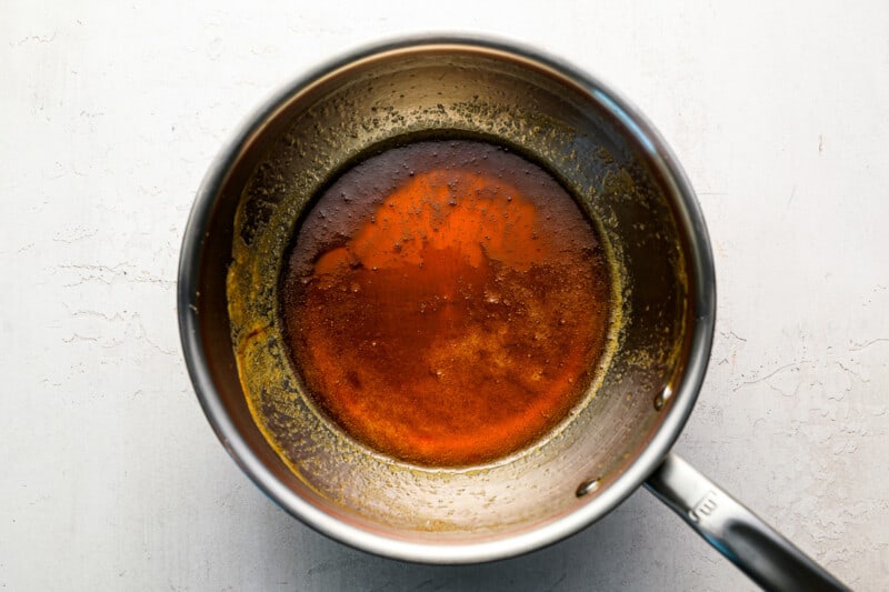 A frying pan filled with a brown sauce.