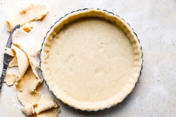A pie crust with a knife next to it.