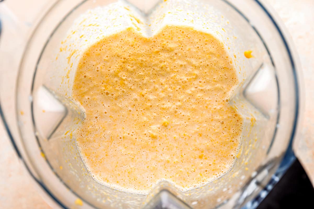 A blender with a yellow cornbread batter in it.