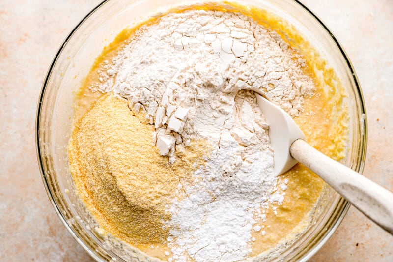 A bowl filled with flour and a spoon.