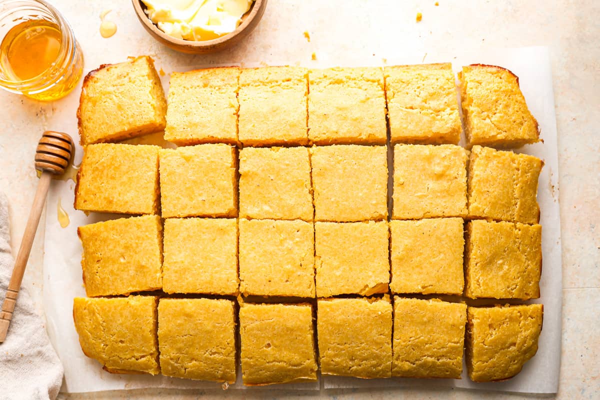 A baking sheet with squares of cornbread on it.