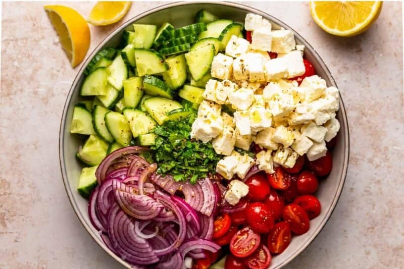 large bowl filled with ingredients for a cucumber tomato salad