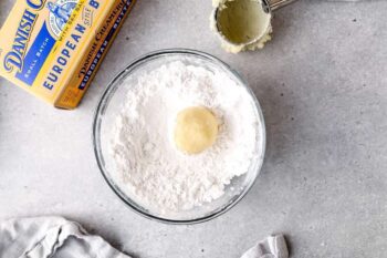 cookie dough ball in a bowl of powdered sugar