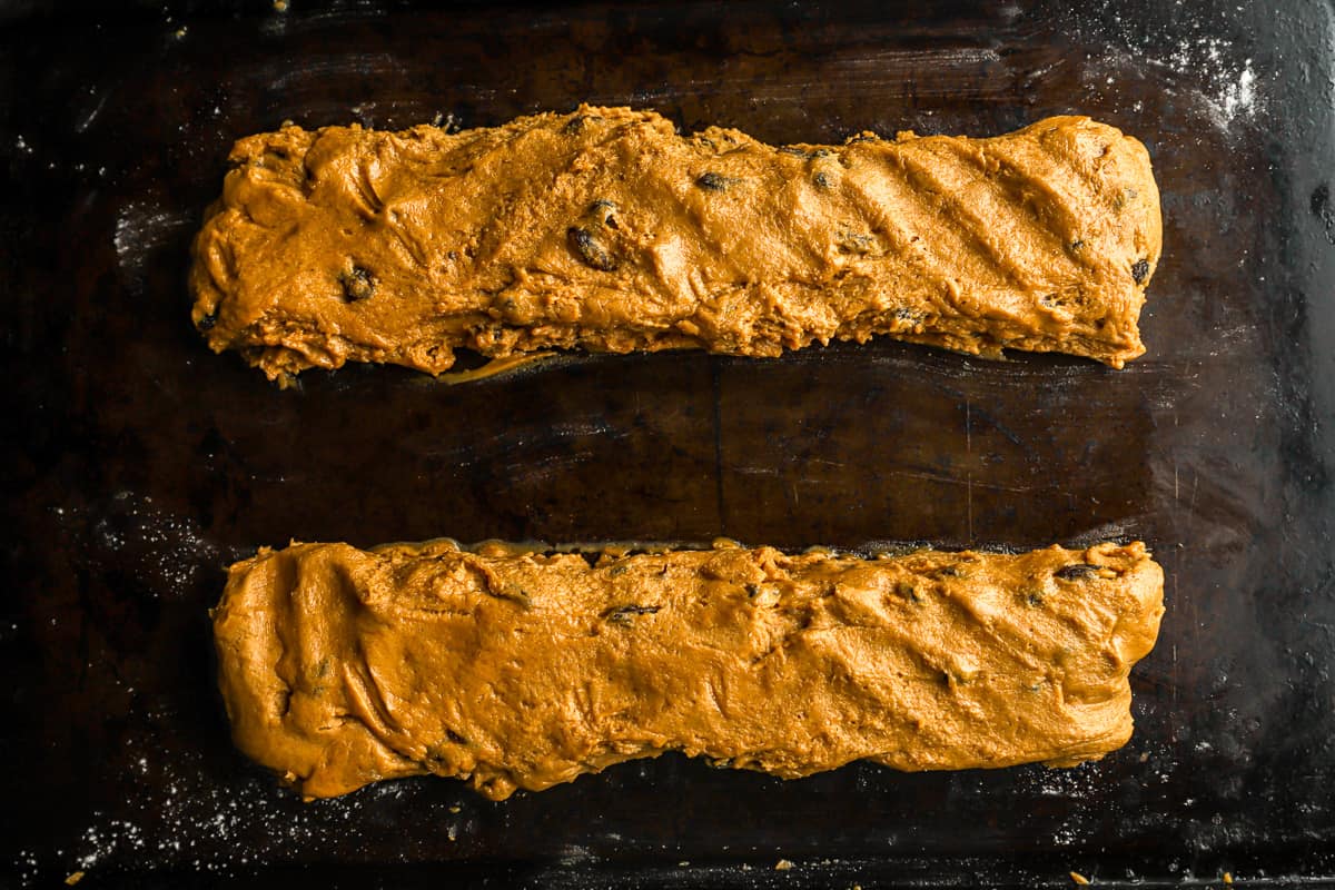 A baking sheet with two long log-shaped cookies on it.