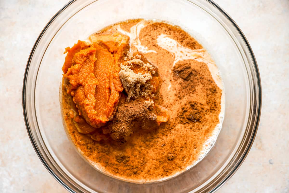 A mixing bowl filled with pumpkin dump cake ingredients.