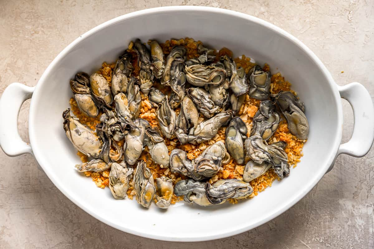 Cracker topping and oysters layered into a casserole dish.