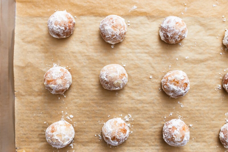 powdered sugar cookies on a baking sheet.