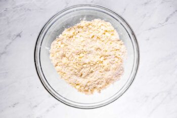 overhead view of dry ingredients for sweet potato pie crust in a glass bowl.