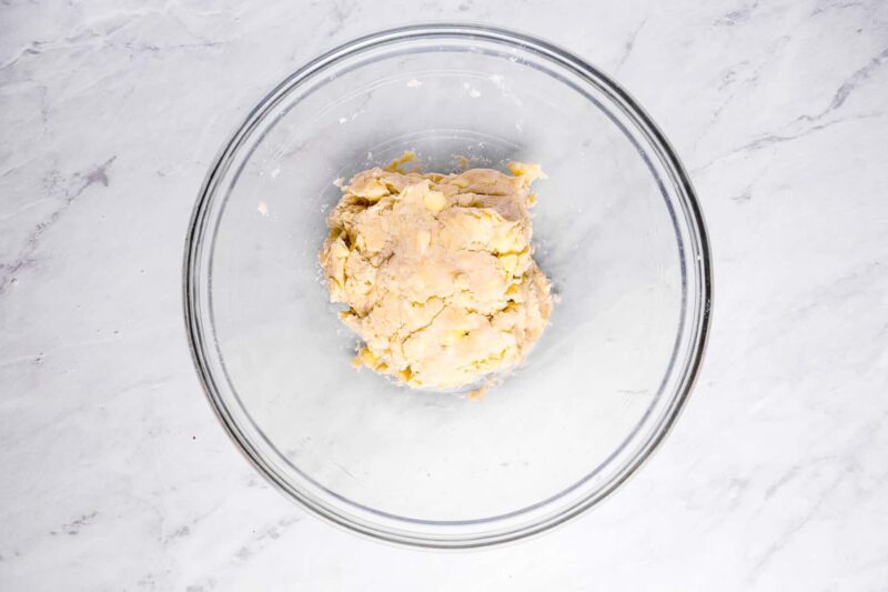 overhead view of sweet potato pie dough in a glass bowl.