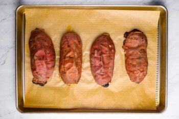overhead view of 4 roasted sweet potato halves on a baking sheet.