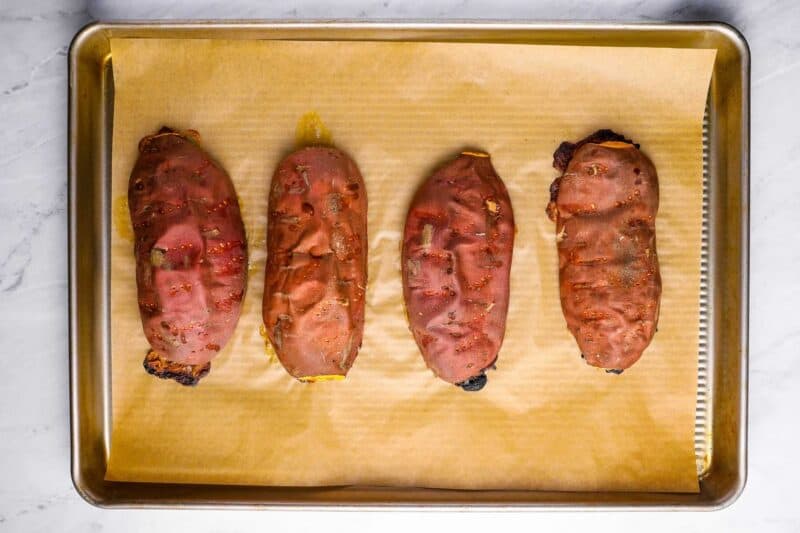 overhead view of 4 roasted sweet potato halves on a baking sheet.