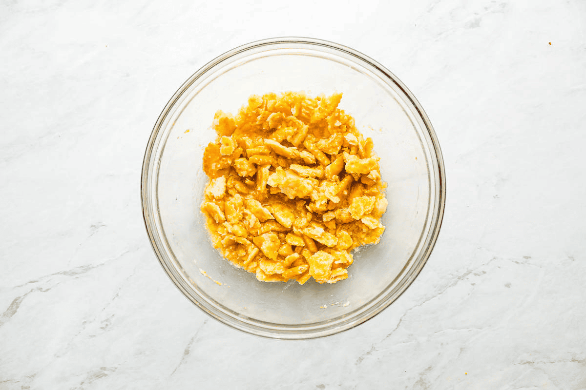 Combining Ritz crackers and butter in a glass bowl. 
