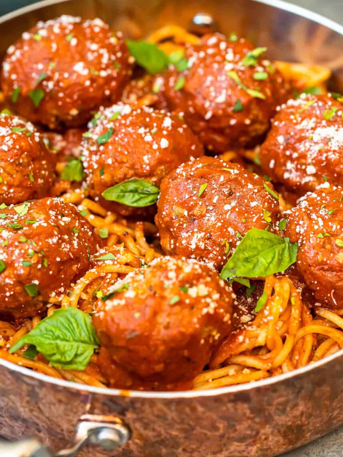 meatballs over pasta in a pan - how to make meatballs.