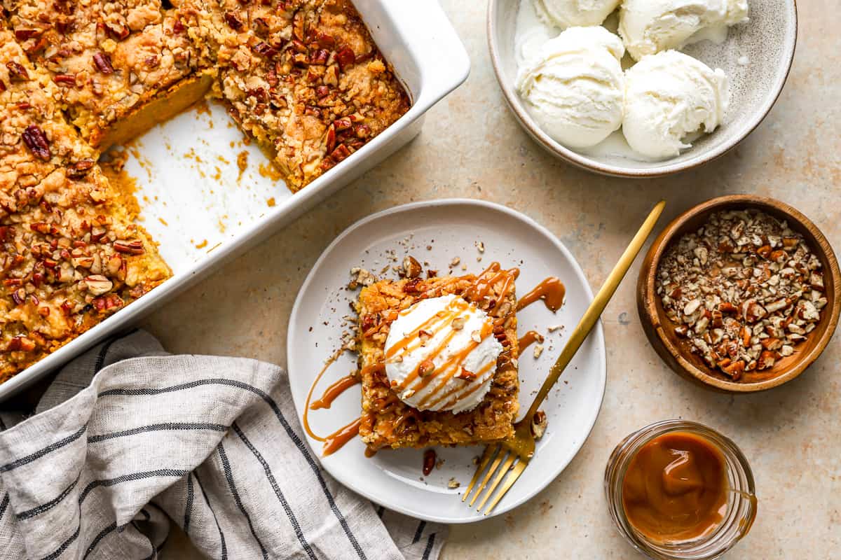 A plate of pumpkin cake with ice cream, surrounded by ingredients.