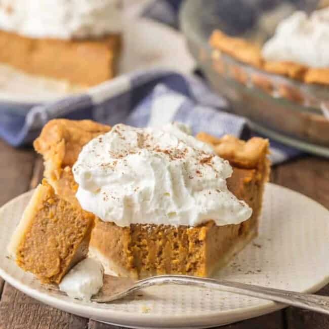 A slice of "pumpkin pie" on a plate with whipped cream.