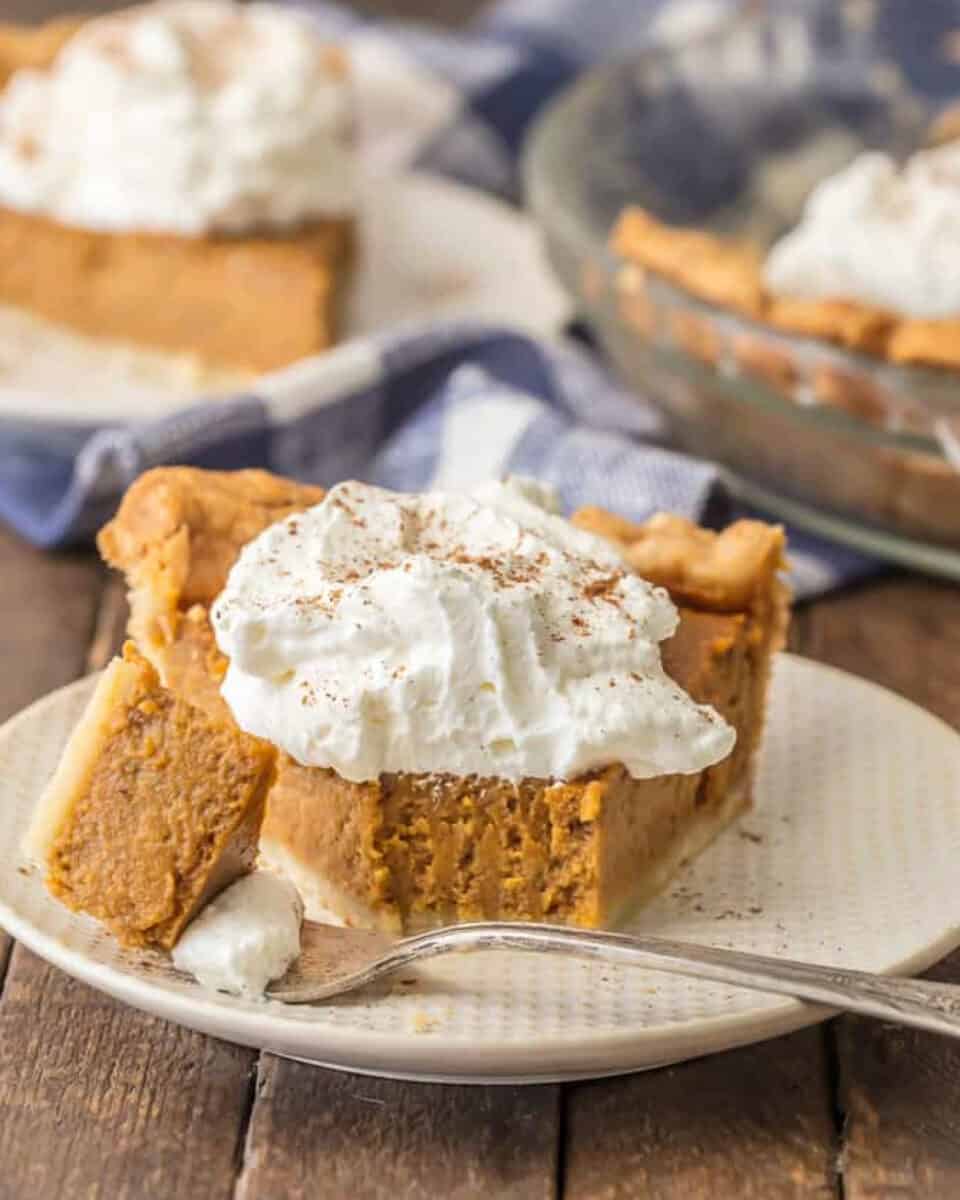 A slice of "pumpkin pie" on a plate with whipped cream.