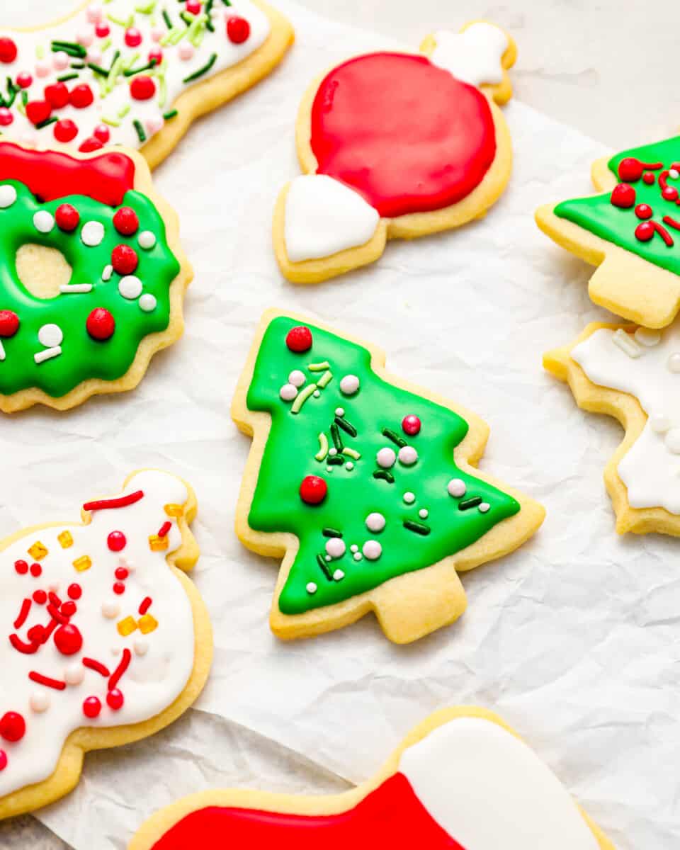 Christmas sugar cookies decorated with royal icing, on parchment paper.