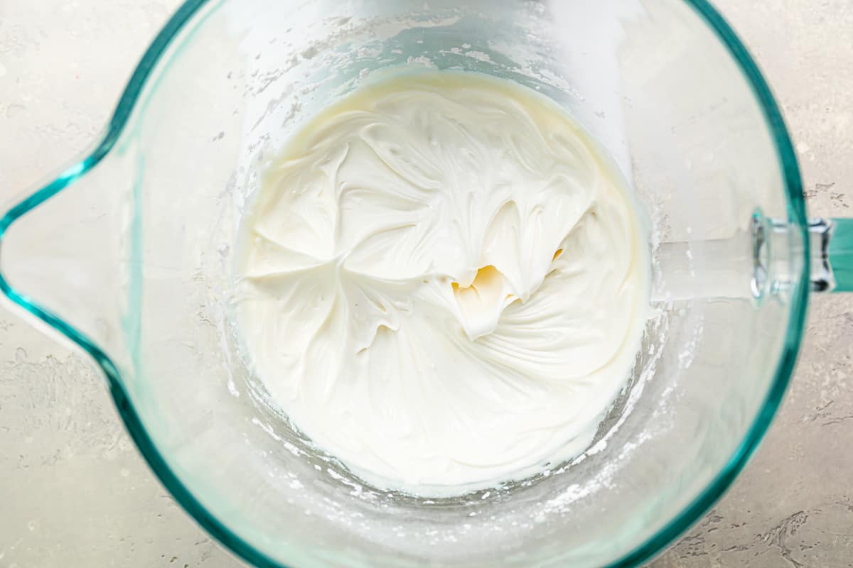 Whipped royal icing in a glass bowl.