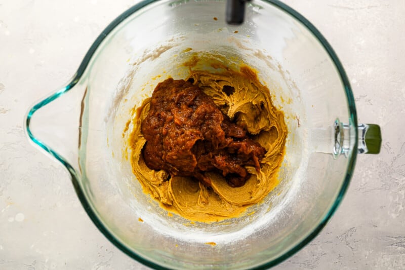 pureed dates added to sticky toffee pudding batter in a glass bowl.