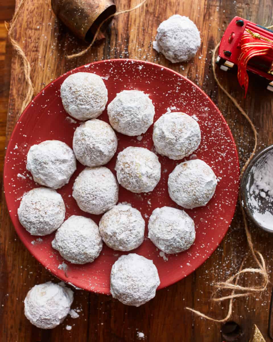 Powdered sugar cookies on a red plate.