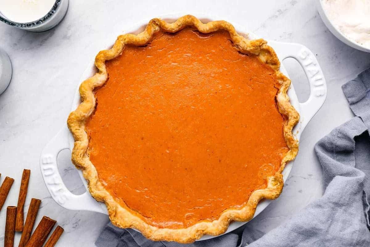 overhead view of sweet potato pie in a white pie pan with handles.