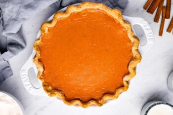overhead view of sweet potato pie in a white pie pan with handles.