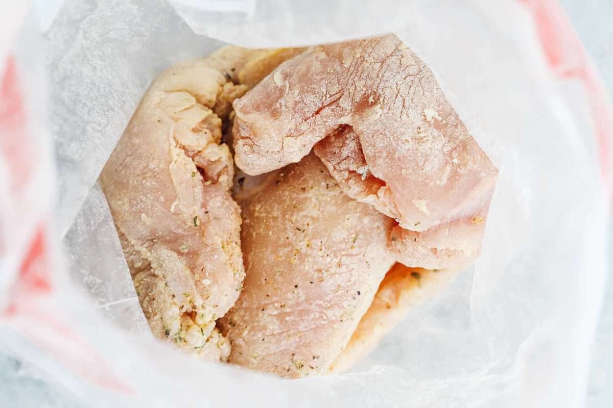 raw chicken breasts and seasoning in a ziplock bag.