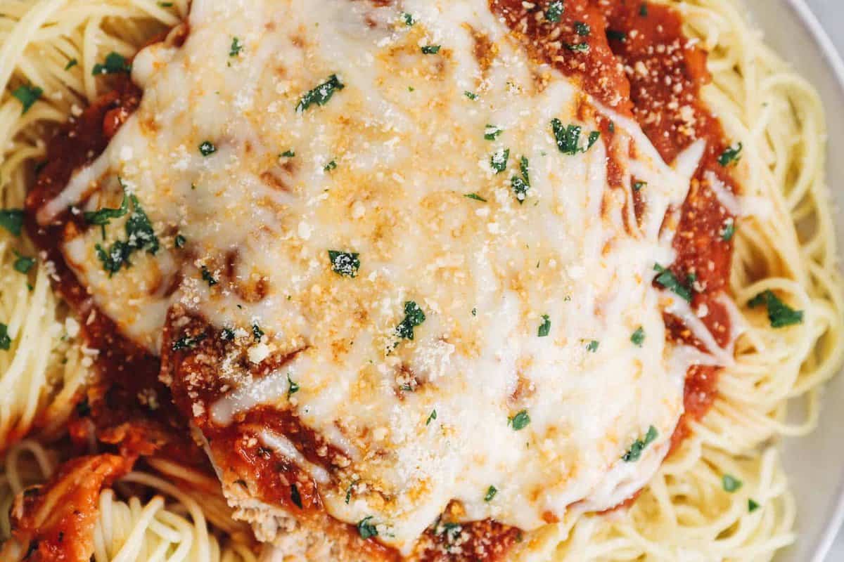 close up of instant pot chicken parmesan on a white plate.