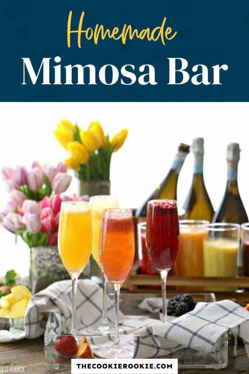 Homemade mimosa bar on a table with flowers and fruit.