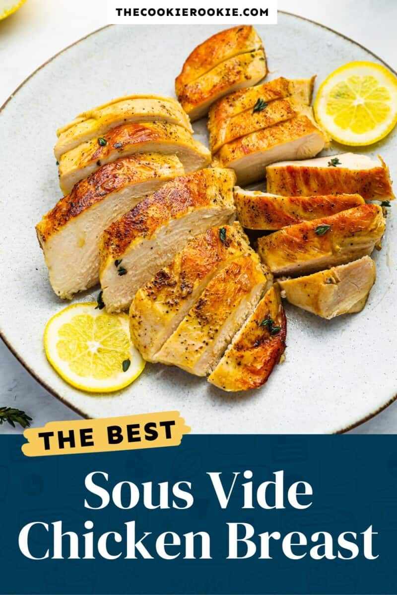 The best sous vide chicken breast on a plate with lemon slices.