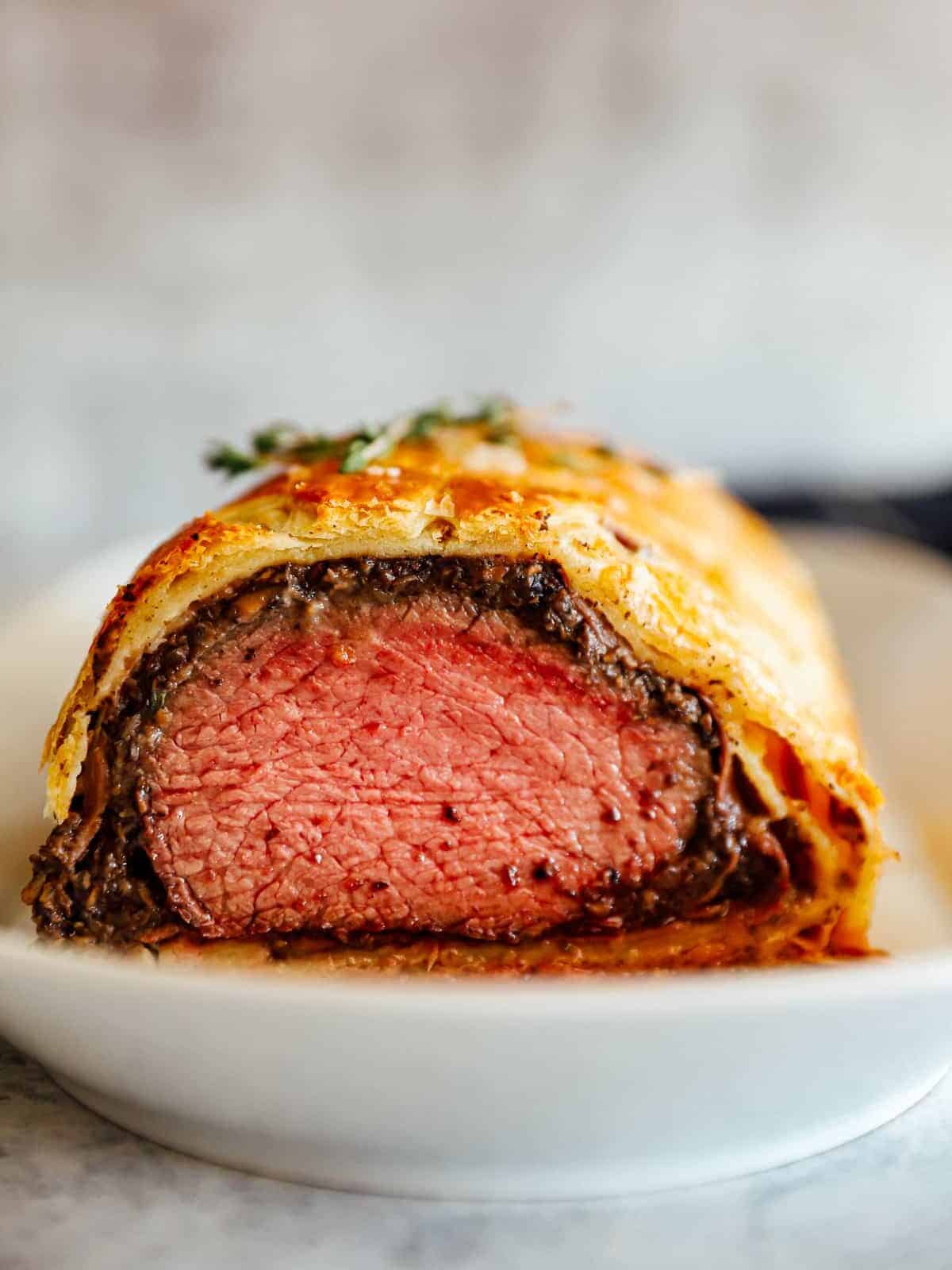 beef Wellington sliced and on a white plate