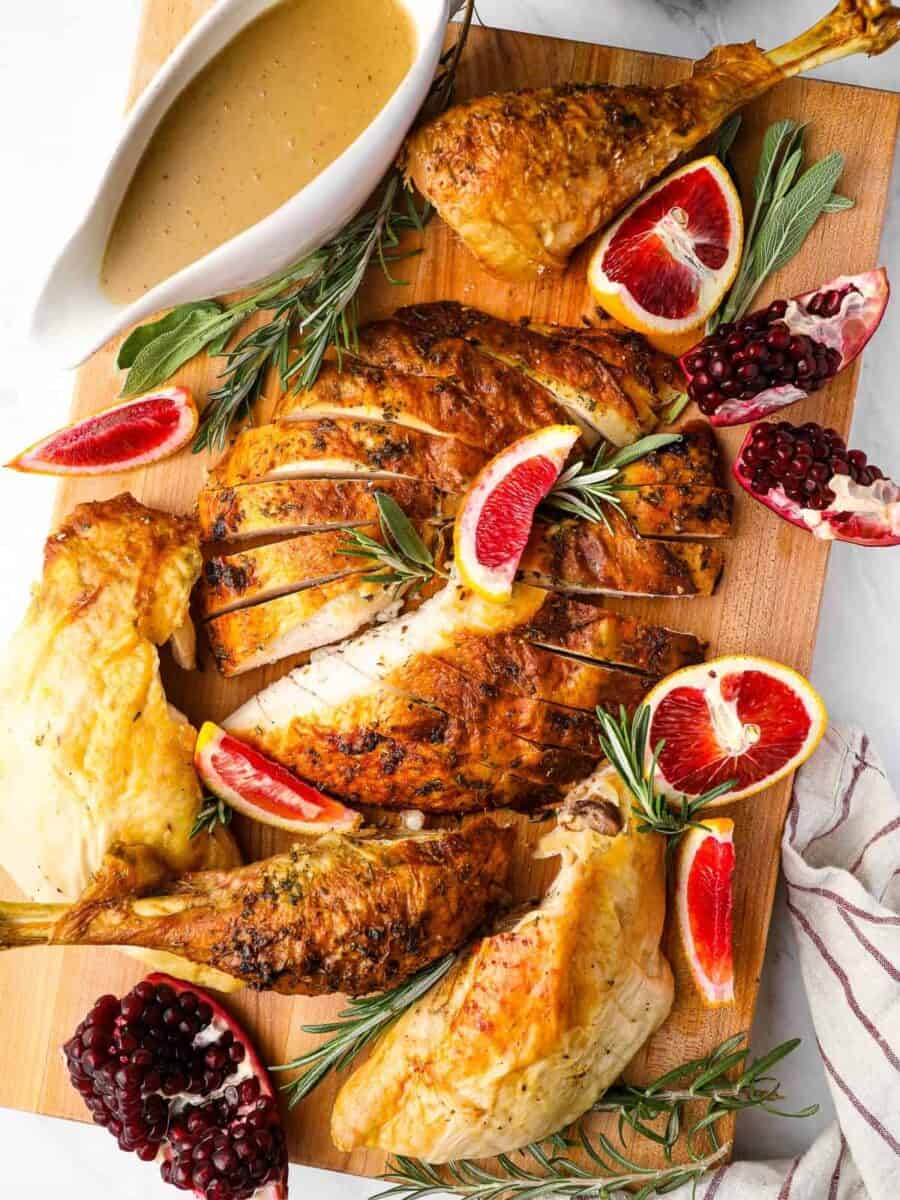 roasted Christmas turkey with turkey gravy on a cutting board.