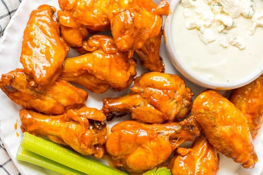 Buffalo Wings with buffalo wing sauce on a plate with ranch and celery