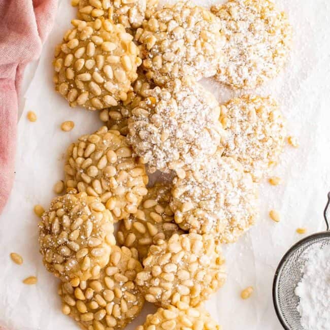 overhead image of pignoli cookies with a dusting of powdered sugar