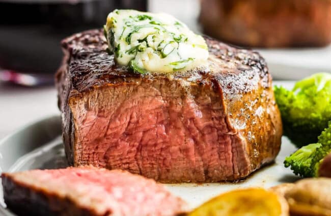 A steak on a plate with broccoli and potatoes.