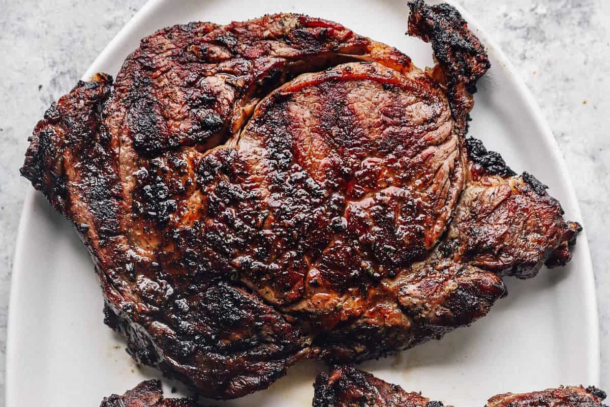 a grilled ribeye steak on a white plate