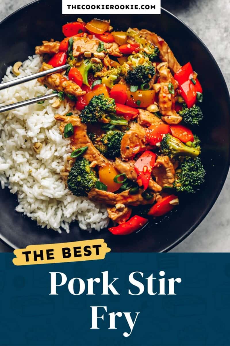 Pork stir fry in a black bowl with rice and vegetables.