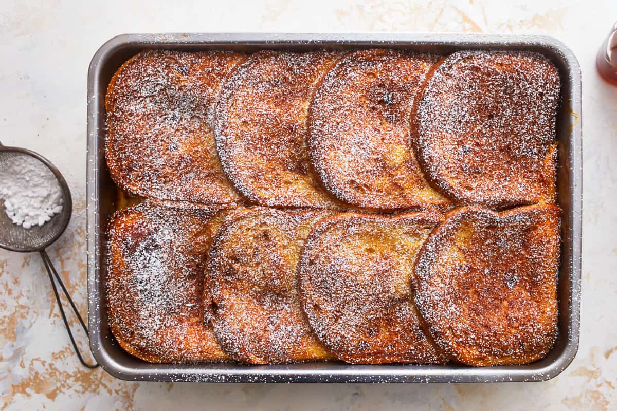 French toast in a pan with powdered sugar.