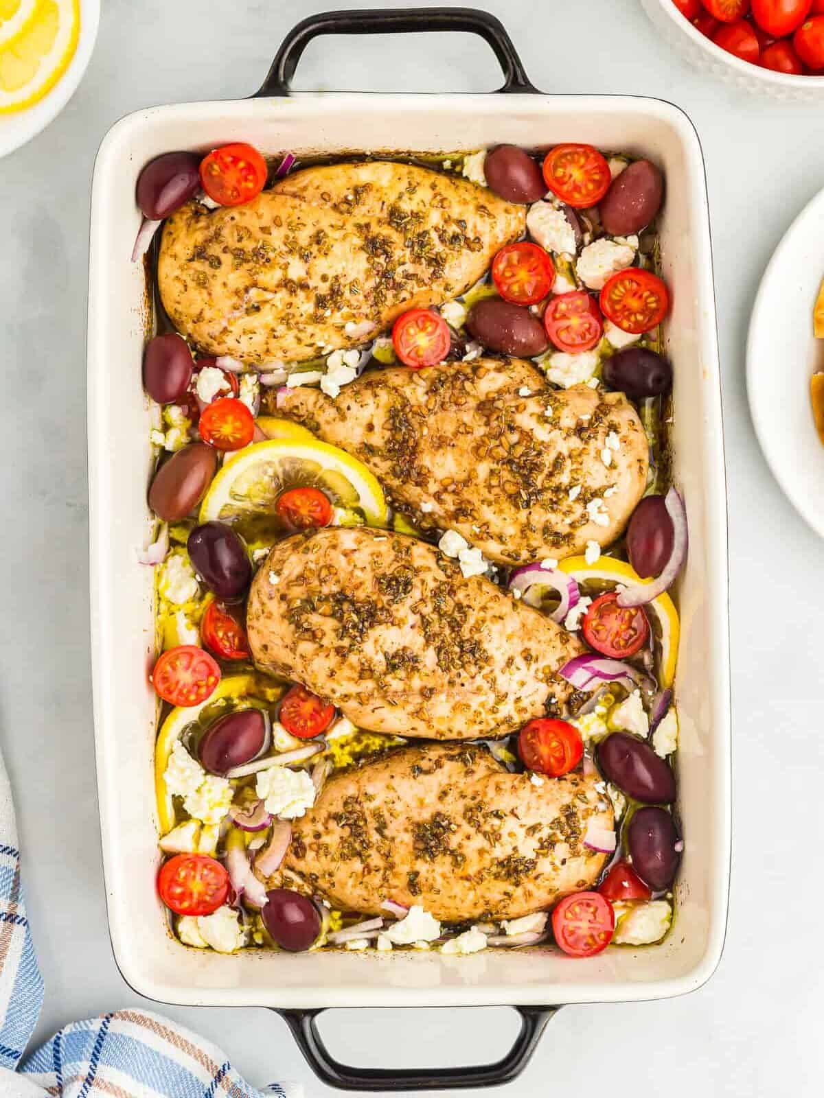 overhead view of baked greek chicken in a rectangular baking dish.