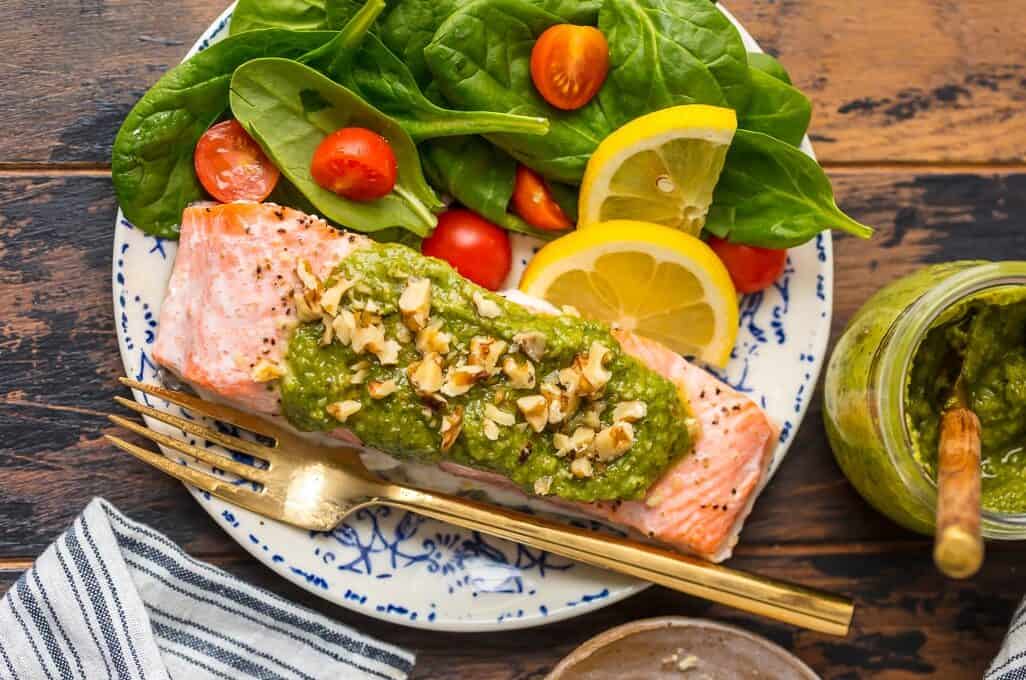 a plate of pesto salmon with salad
