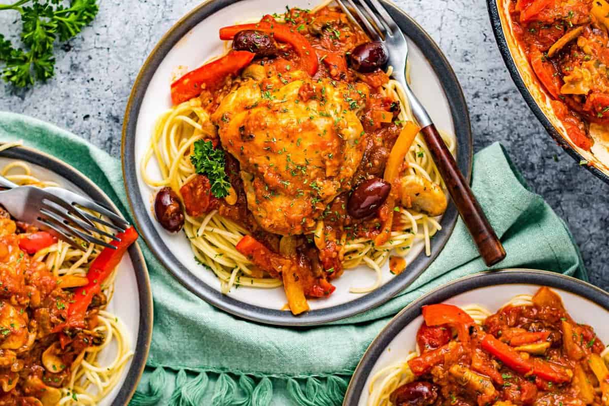 overhead three plates of pasta and chicken cacciatore