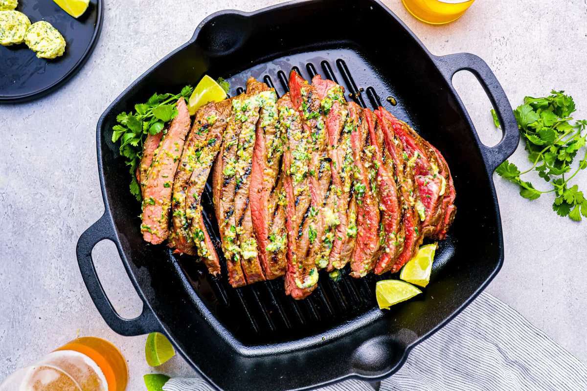 grill pan with flank steak, lemon slices, and cilantro