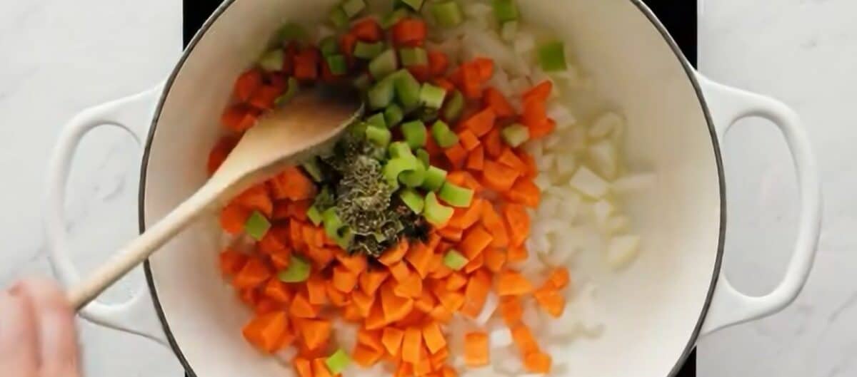 Sauteeing veggies and seasonings in a Dutch oven. 