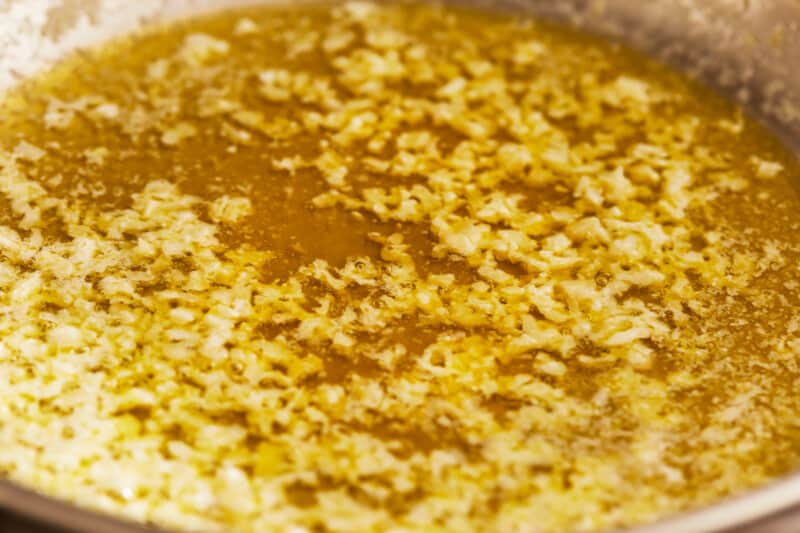A frying pan filled with a sizzling mixture of flour and oil, perfect for cooking delicious BBQ shrimp.