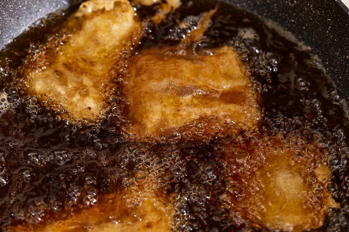Fish fillets frying in oil.